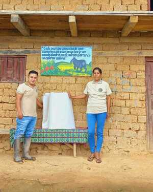 Lush green mountains under a clear blue sky with a few clouds.